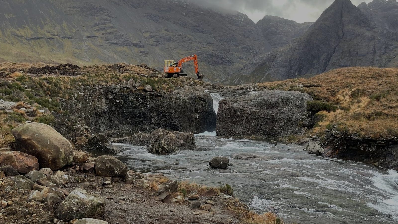 CR Contractors excavator working beside a Highland waterfall